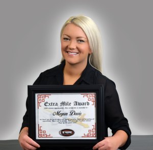 Megan Davis holding her Extra Mile Award certificate.